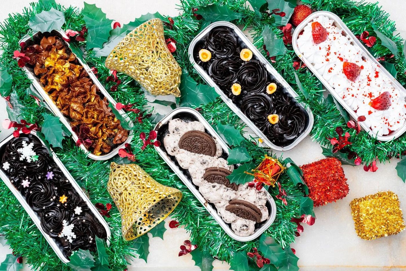 Assorted festive dessert tubs arranged with Christmas decorations