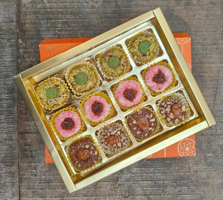 Festive gift box of assorted handcrafted Indian sweets with pistachio and rose toppings